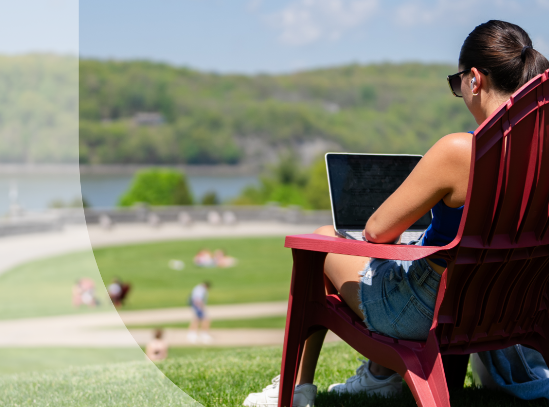 A student relaxing in a lawn chair overlooking the Hudson River.