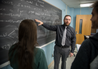 Professor points to blackboard. 