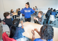 Teacher talks to group of young students. 