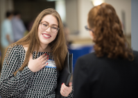 Student greets professor at event. 