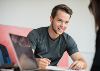 Student smiles while writing. 